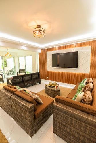 a living room with two couches and a flat screen tv at Villa Lugo Lahoz in San Felipe de Puerto Plata