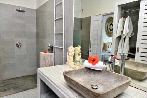 a bathroom with a concrete sink and a mirror at Bali Cosy Villas Seminyak in Legian