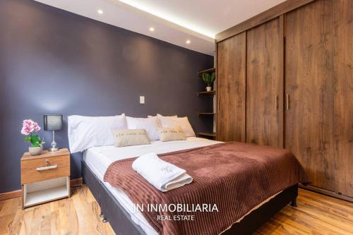 a bedroom with a large bed with a wooden wall at Espectacular Apartamento 2 minutos del JMC Nuevo in Rionegro