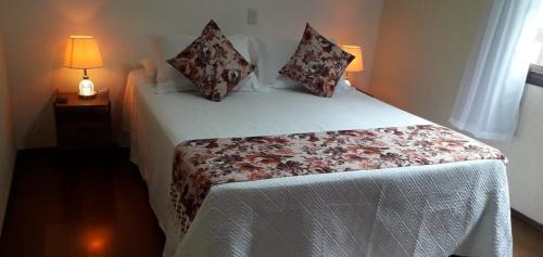 1 dormitorio con 1 cama y 1 lámpara en una mesa en apartamento águas de lindoia itaigara en Águas de Lindóia