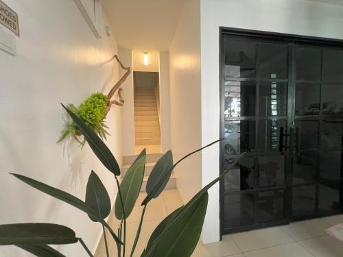 uma planta num quarto ao lado de uma porta de vidro em Cozy Suite for 2 - 6 pax near Kek Lok Si & Penang Hill, Dual key system em Ayer Itam