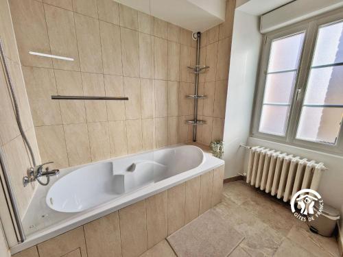 y baño con bañera y ventana. en Gîte Sainte-Suzanne-et-Chammes, 5 pièces, 8 personnes - FR-1-600-242, en Sainte-Suzanne