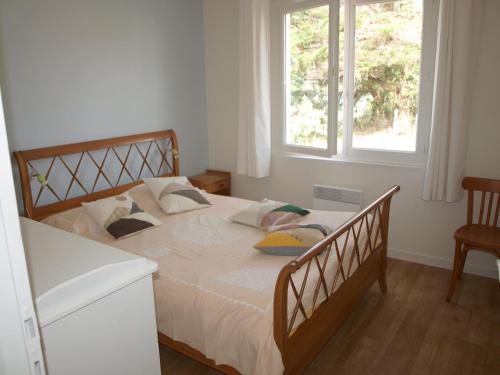 une chambre avec un grand lit avec deux fenêtres dans l'établissement Maison 3 Chambres avec Jardin et Wi-Fi à 10 min de la Plage, Quartier Calme, Animaux Acceptés - FR-1-323-370, à Saint-Jean-de-Monts