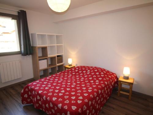 - une chambre avec un lit rouge et deux lumières sur deux tables dans l'établissement Confortable T3 à 50m des pistes avec piscine et parking gratuits - FR-1-297-338, à Auris
