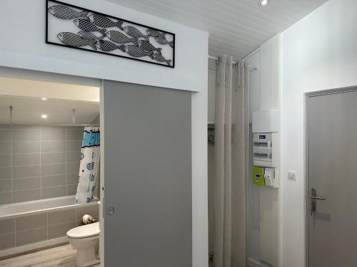 La salle de bains est pourvue de toilettes et d'une télévision murale. dans l'établissement Appartement lumineux et spacieux à deux pas de la plage de Seignosse - FR-1-239-1042, à Seignosse