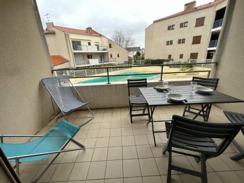 d'un balcon avec une table, des chaises et une piscine. dans l'établissement Appartement T2 à St Jean de Monts avec balcon et parking privé - FR-1-324A-67, à Saint-Jean-de-Monts