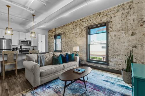 a living room with a couch and a table at Brick & Bed Riverfront Lofts, PC 205 in Saint Louis