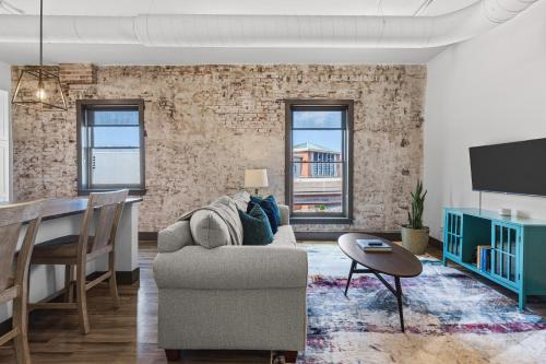 a living room with a couch and a table at Brick & Bed Riverfront Lofts, PC 205 in Saint Louis