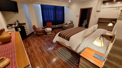 Un dormitorio con una cama grande y una sala de estar. en Hotel de Sal Atipax, en Uyuni