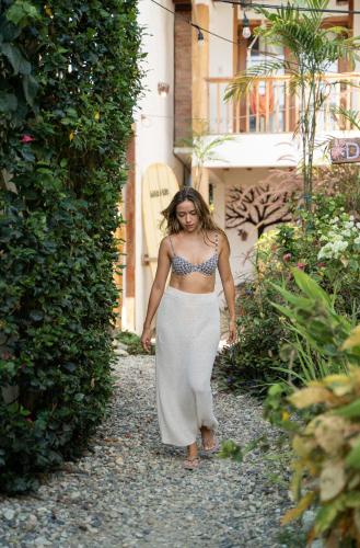 a woman in a dress walking down a path at Ganso & Búho in Ayampe