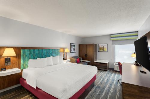 ブリッジポートにあるHampton Inn Bridgeport/Clarksburgの大きなベッドとデスクが備わるホテルルームです。