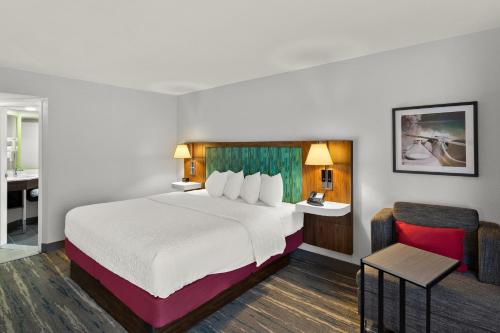 a hotel room with a large bed and a bathroom at Hampton Inn Bridgeport/Clarksburg in Bridgeport