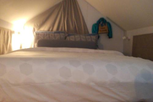 een groot wit bed in een slaapkamer met bij BRAND NEW Beachfront Tiny Home Oniro in Koh Samui 