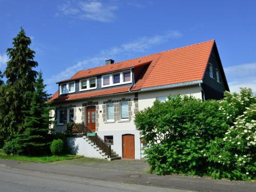 a white house with an orange roof at apartment in the Hochsauer region quiet location in Stormbruch