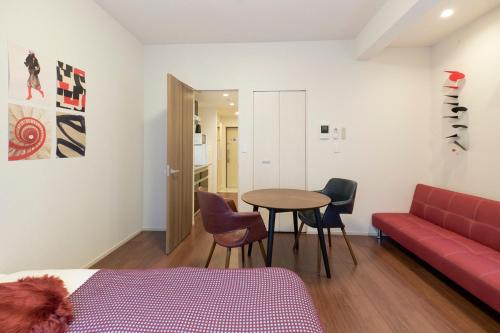 a room with a couch and a table and chairs at G-Stage 01 IKEBUKURO in Tokyo