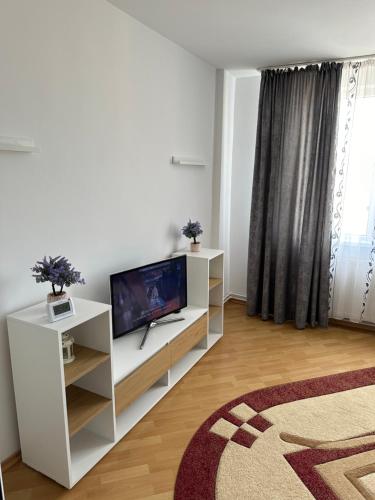a living room with a tv on a white cabinet at Apartament Amalia in Roman