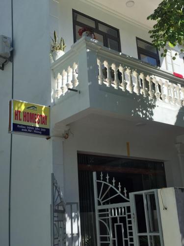 un edificio con un balcón con un cartel. en HT Homestay Cát Bà en Cat Ba