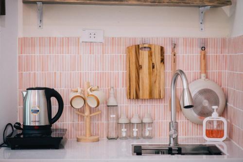 a kitchen counter with a sink and many kitchen utensils at MiaCasaHanoi - King Bed - Free laundry - Netflix & Rooftop Chill in Hanoi