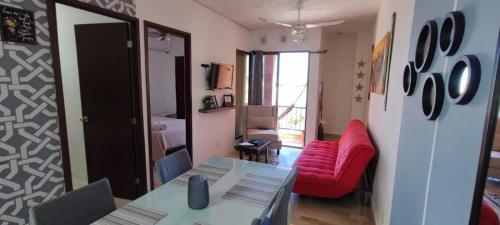 a living room with a red couch and a table at Villa Caribe Cancún in Cancún