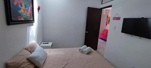 a bedroom with a bed and a flat screen tv at Villa Caribe Cancún in Cancún