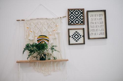 a shelf with a plant on a wall with pictures at MiaCasaHanoi - King Bed - Free laundry - Netflix & Rooftop Chill in Hanoi