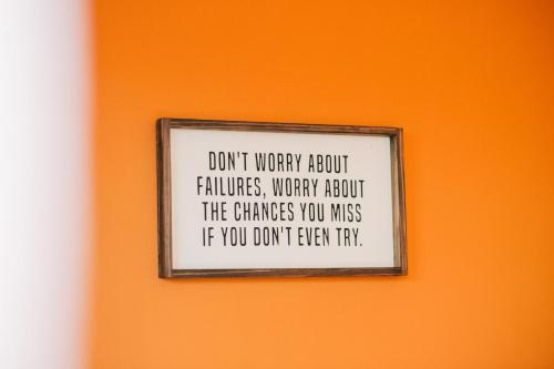 a sign on an orange wall with a quote at MiaCasaHanoi - King Bed - Free laundry - Netflix & Rooftop Chill in Hanoi