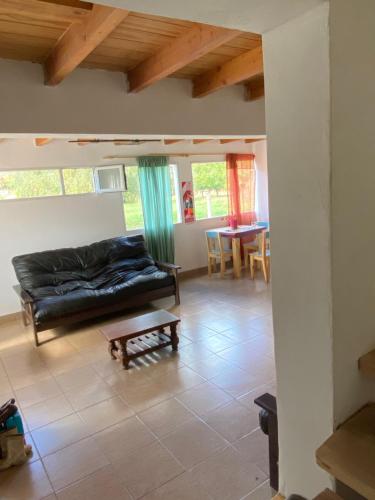 uma sala de estar com um sofá e uma mesa em Hostel Verde Mondo em El Bolsón