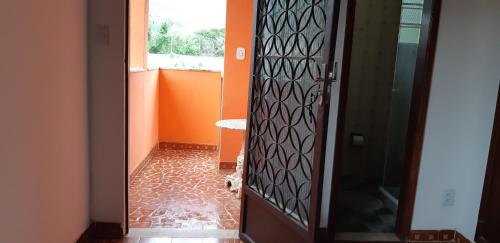 a cat standing in a hallway looking through a door at Ponta Negra Hospedagem in Maricá