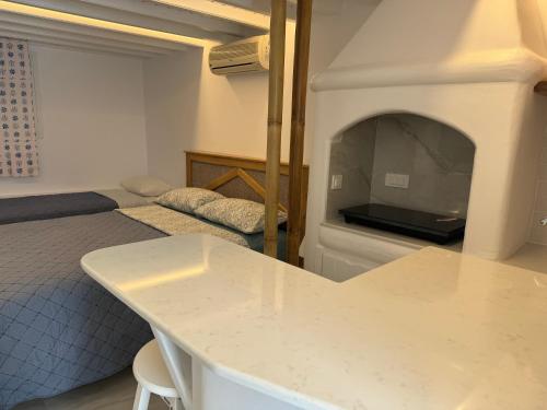 a bedroom with a bed with a fireplace and a table at Anais in Mikonos