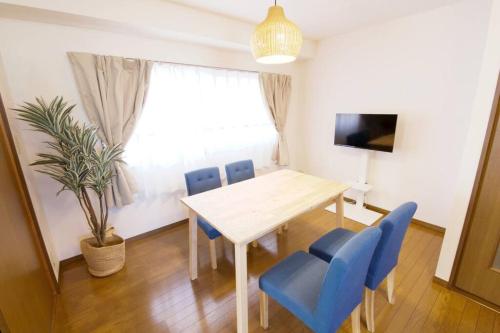 a dining room with a table and blue chairs at NH building5F in Tokyo