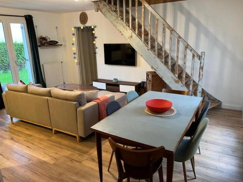 un salon avec une table et un canapé dans l'établissement Maison avec grand jardin proche de Pegasus Bridge, à Ranville