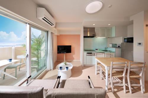 eine Küche und ein Esszimmer mit einem Tisch und Stühlen in der Unterkunft City Life Miyako L'avenir in Miyako-jima