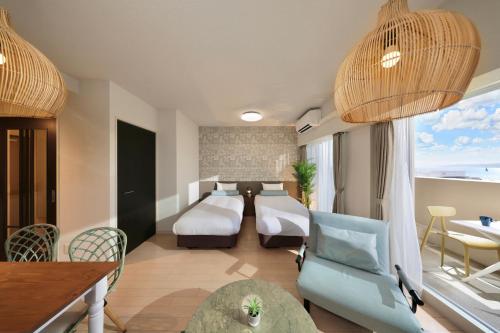 a hotel room with a bed and a table and chairs at City Life Miyako L'avenir in Miyako-jima