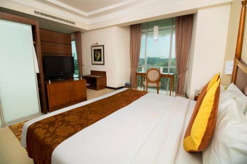 a hotel room with a large bed and a television at Nilai Springs Resort Hotel in Nilai