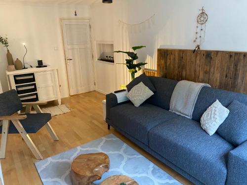 a living room with a blue couch and a table at Bed & Breakfast De Plenkert in Valkenburg