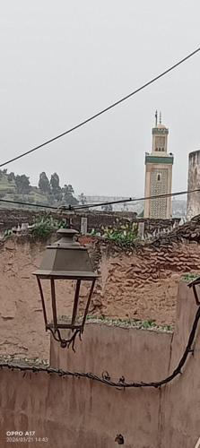 a street light next to a wall with a building at ESC Apartments in Fès