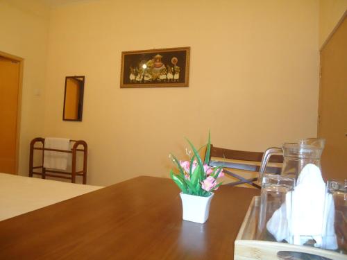 a table with a vase of flowers on top of it at Guest House in Kaduwela
