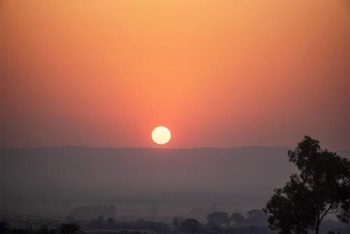 a sunset with the sun in the sky at STONE Mansion by Phoenix Stays Igatpuri in Igatpuri
