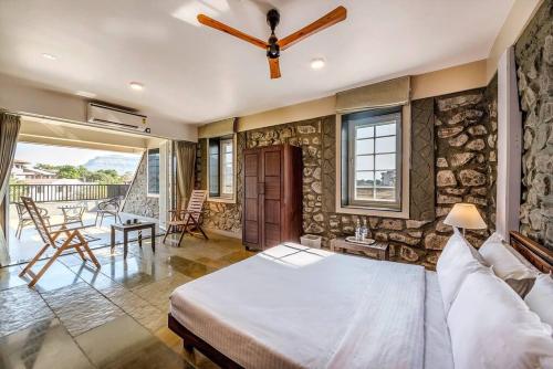 a bedroom with a bed and a stone wall at STONE Mansion by Phoenix Stays Igatpuri in Igatpuri