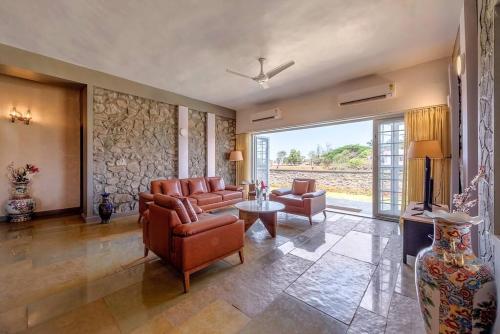 a living room with a couch and chairs and a table at STONE Mansion by Phoenix Stays Igatpuri in Igatpuri