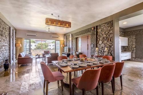 a dining room and living room with a table and chairs at STONE Mansion by Phoenix Stays Igatpuri in Igatpuri
