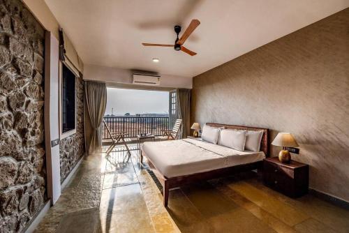 a bedroom with a bed and a ceiling fan at STONE Mansion by Phoenix Stays Igatpuri in Igatpuri