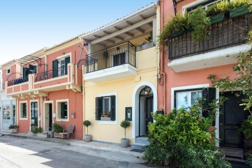 a row of pink and yellow houses on a street at Bay View House in Corfu
