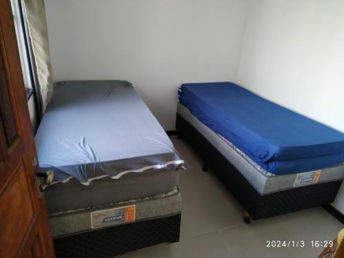 two twin beds sitting next to each other in a room at Casa 345 Mucuri-ba in Mucuri