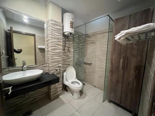 y baño con lavabo, aseo y ducha. en Islamabad Premium Hotel en Islamabad