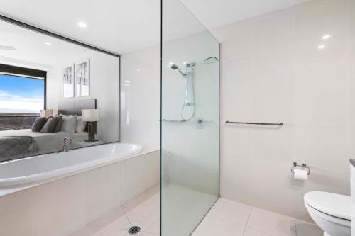 a bathroom with a shower and a tub and a sink at Circle on Cavill - Self Contained & Privately Managed - Wow Stay in Gold Coast