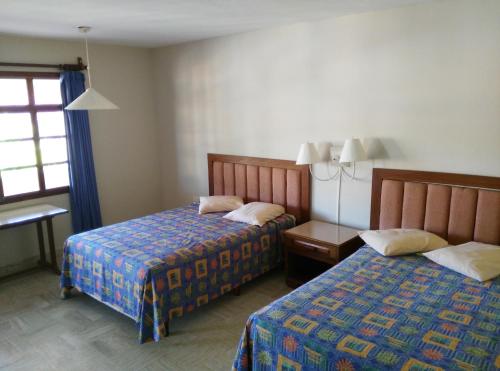 ein Hotelzimmer mit 2 Betten und einem Fenster in der Unterkunft Hotel Debliz Xpujil in Chicanna
