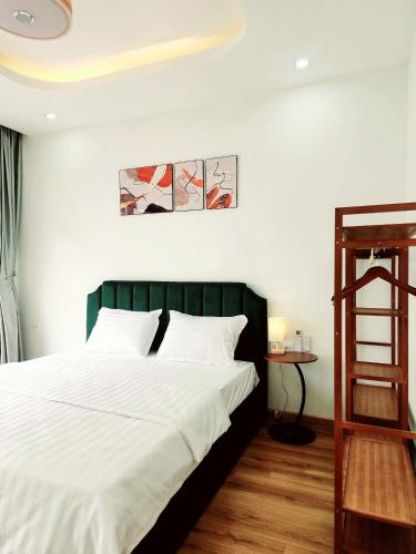 a bedroom with a bed with white sheets and a ladder at Timi Homestay Near the Wave Park Ocean Park 2 in Hòa Bình