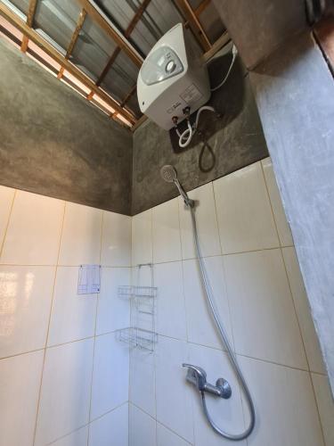 a shower with a shower head in a bathroom at One Love Homestay in Jimbaran