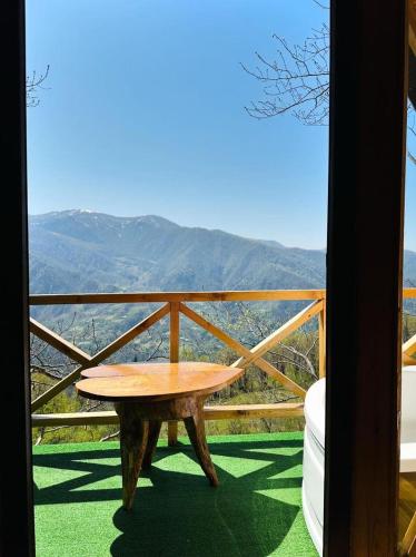 a table on a balcony with a view of the mountains at cottage panorama merisi in Inasharidzeebi